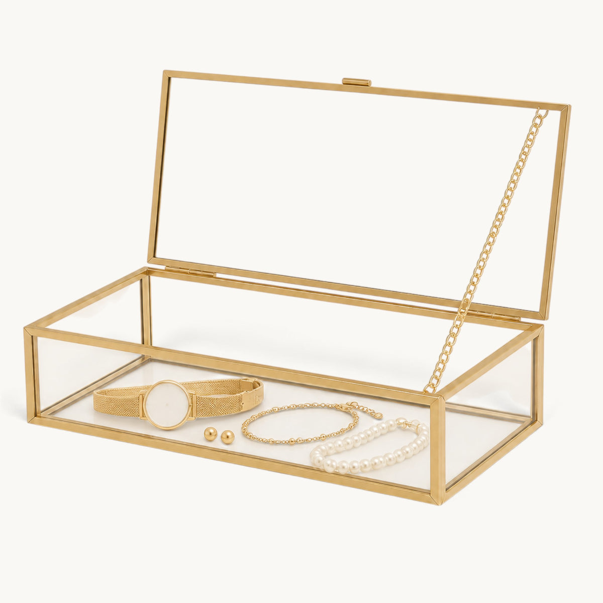 Boîte à bijoux en verre et doré ouverte avec montre, bracelet et perles