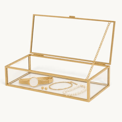 Boîte à bijoux en verre et doré ouverte avec montre, bracelet et perles