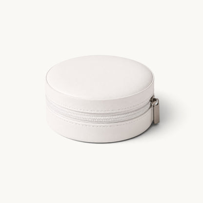 Boîte à bijoux ronde de voyage blanche fermée, extérieur effet cuir et fermeture à glissière