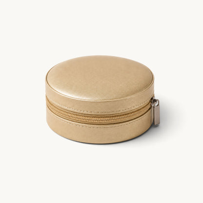 Boîte à bijoux ronde de voyage dorée fermée, extérieur effet cuir et fermeture à glissière