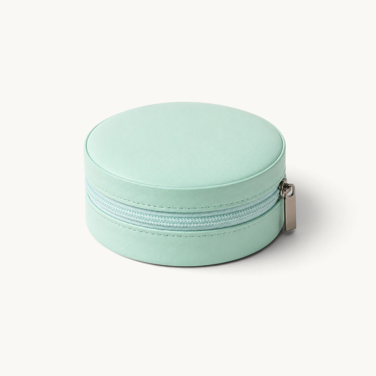Boîte à bijoux ronde de voyage vert menthe fermée, extérieur effet cuir et fermeture à glissière