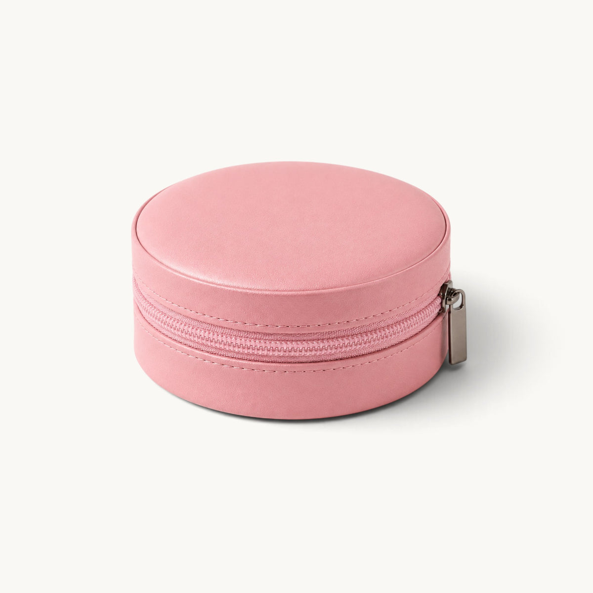 Boîte à bijoux ronde de voyage rose fermée, extérieur effet cuir et fermeture à glissière
