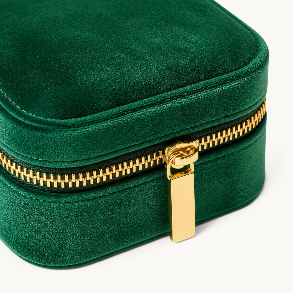 Détail de la fermeture dorée d’une boîte à bijoux de voyage en velours vert émeraude