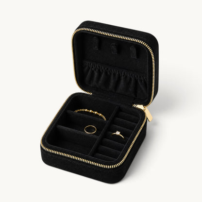 Boîte à bijoux de voyage en velours noir ouverte avec rangements pour bagues et colliers
