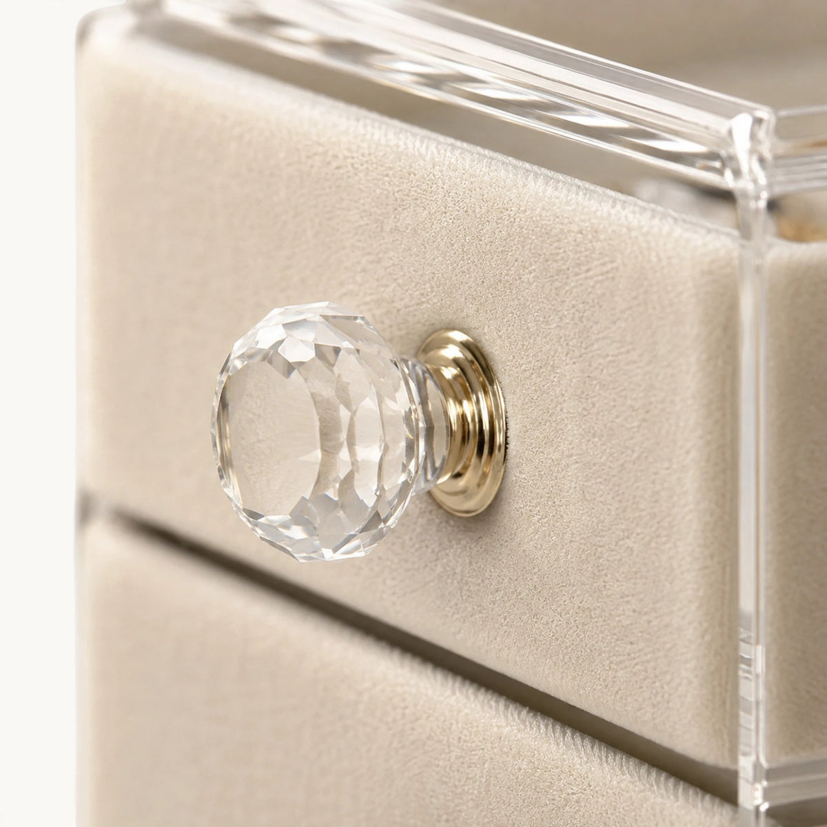 Gros plan sur le bouton en cristal taillé de l'organisateur de bijoux à tiroirs et son velours beige
